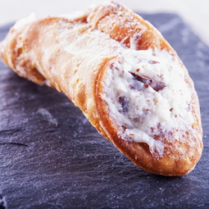 Cannolo over black stone, close up, square image