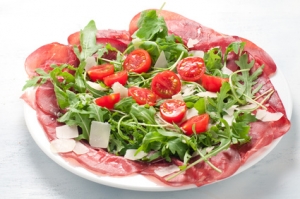 Plate of bresaola with rocket parmesan and cherry tomatoes